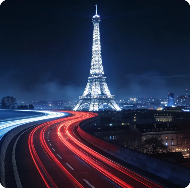 The Eiffel Tower at night with light trails from passing traffic